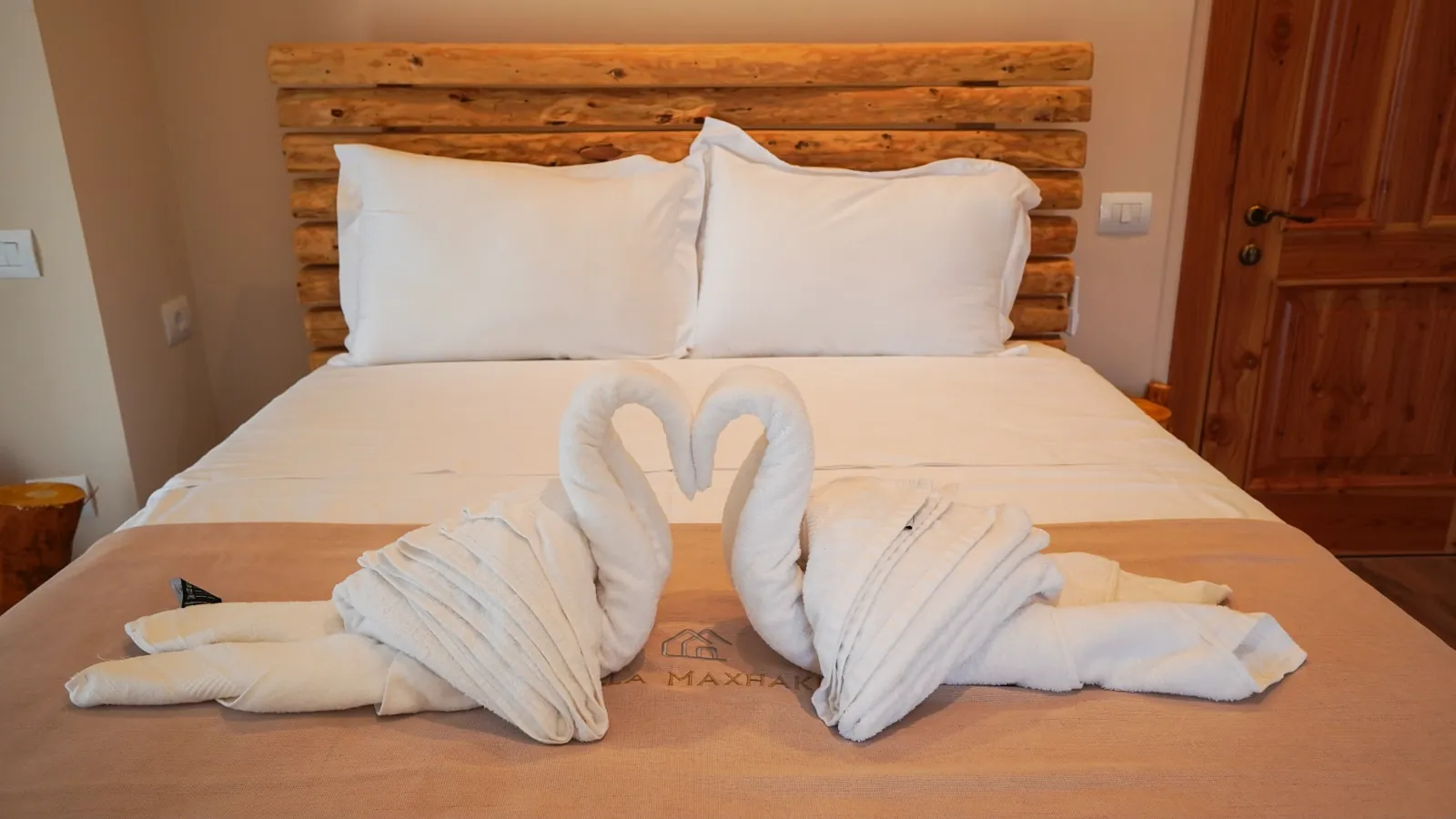 Bed dressed with towel swans at Villa Maxhaku