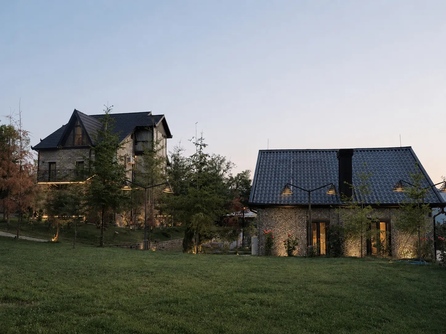 Villa buildings across the garden lawn at dusk