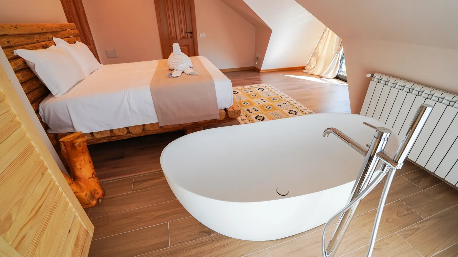 Suite with a freestanding bathtub and a log bed