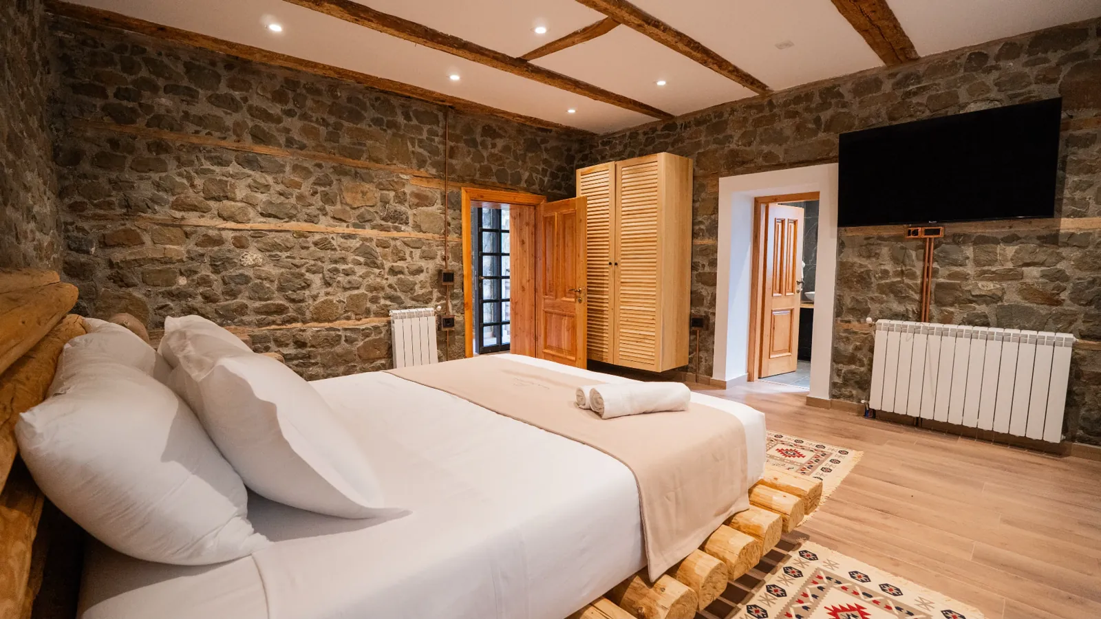 Bedroom with a wooden wardrobe and a wall-mounted TV